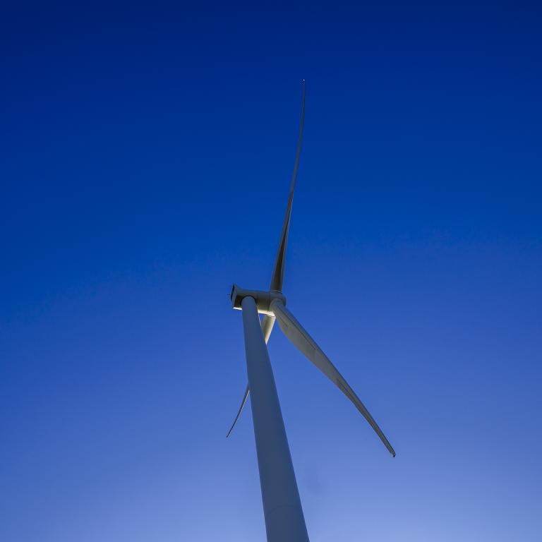 Single wind turbine in blue sky